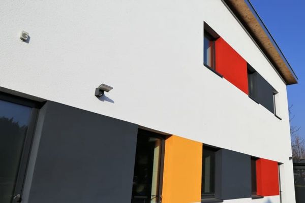Foto mit einer bunten Hausfassade in rot, gelb, grau und weiß